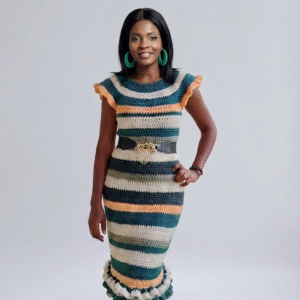 "Mannequin portant la robe Horizon de Mailles de Dear San'el, une robe longue en crochet aux rayures vert forêt, ocre et crème avec volants aux manches et au bas."