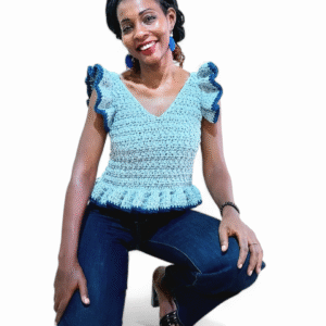 Femme portant un top peplum en crochet bleu clair avec des bordures bleu foncé, des bretelles volantées et un col en V.